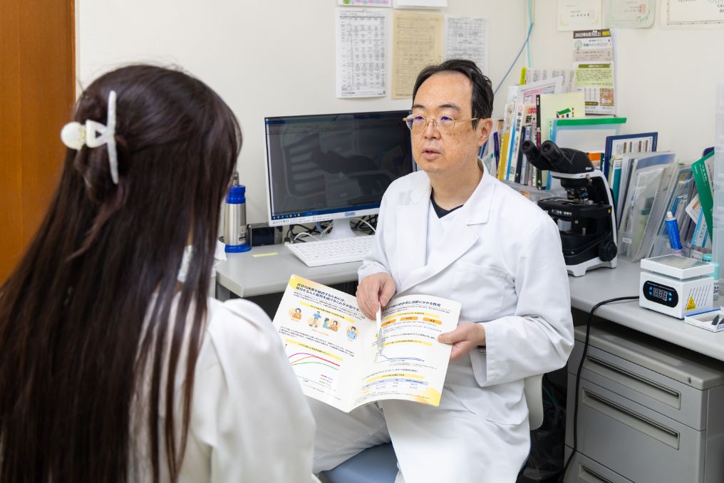 院長が患者さまに資料を見せながら説明している様子